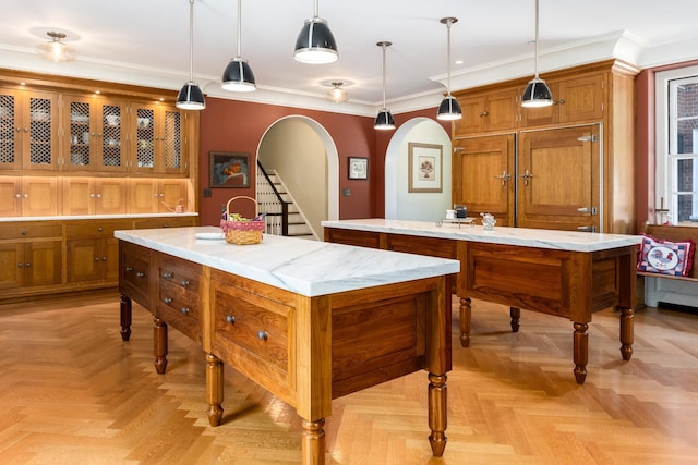 842 Sleepy Hollow Rd, Briarcliff Manor, NY 10510 - kitchen featuring a kitchen island, arched walkways, brown cabinets, crown molding, and hanging light fixtures