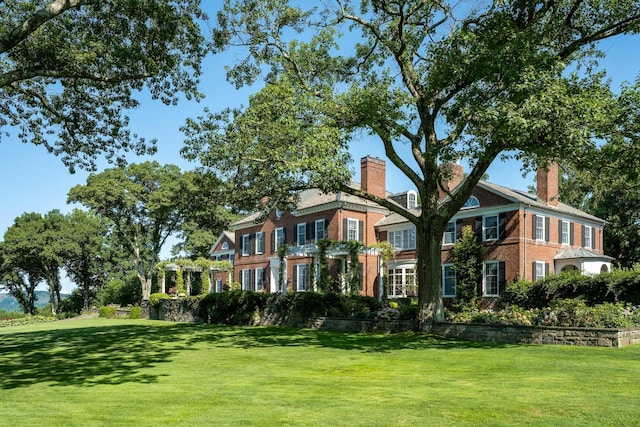 842 Sleepy Hollow Rd, Briarcliff Manor, NY 10510 - colonial-style house featuring a front yard, brick siding, and a chimney