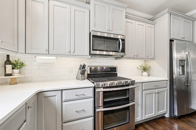 35 Laurel Cir, Goshen, NY 10924 - kitchen featuring stainless steel appliances, dark wood-style flooring, crown molding, tasteful backsplash, and light countertops