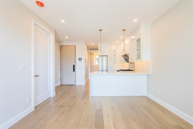 4209 Hampton St Unit 4B, Elmhurst, NY 11373 - kitchen featuring stainless steel fridge, a peninsula, glass insert cabinets, white cabinets, and under cabinet range hood