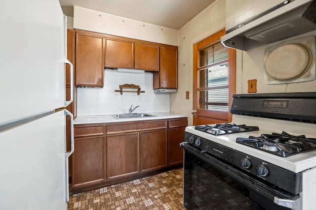628 8th Ave, New Hyde Park, NY 11040 - kitchen featuring freestanding refrigerator, gas stove, ventilation hood, brown cabinetry, and light countertops
