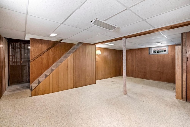 628 8th Ave, New Hyde Park, NY 11040 - basement with wooden walls, a paneled ceiling, carpet, and stairs