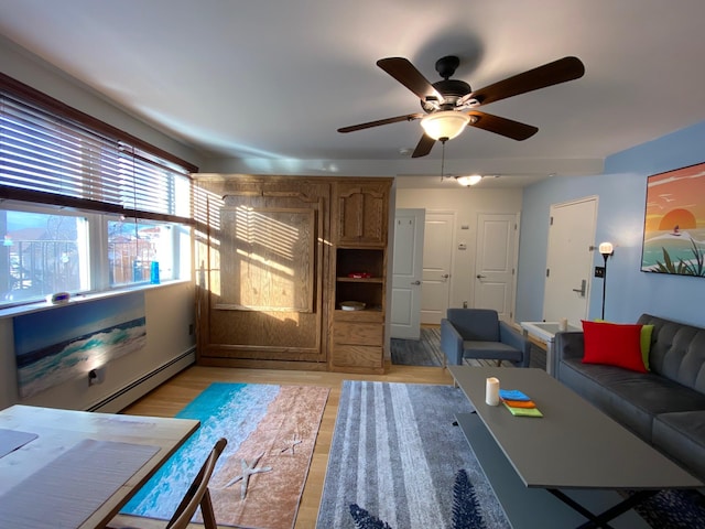 255 W Broadway Unit 303, Long Beach, NY 11561 - living area featuring a baseboard heating unit, ceiling fan, and light wood-style flooring
