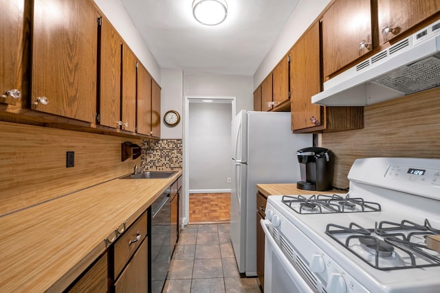 1 Birchwood Ct Unit 1N, Mineola, NY 11501 - kitchen with white gas range oven, under cabinet range hood, stainless steel dishwasher, backsplash, and brown cabinets