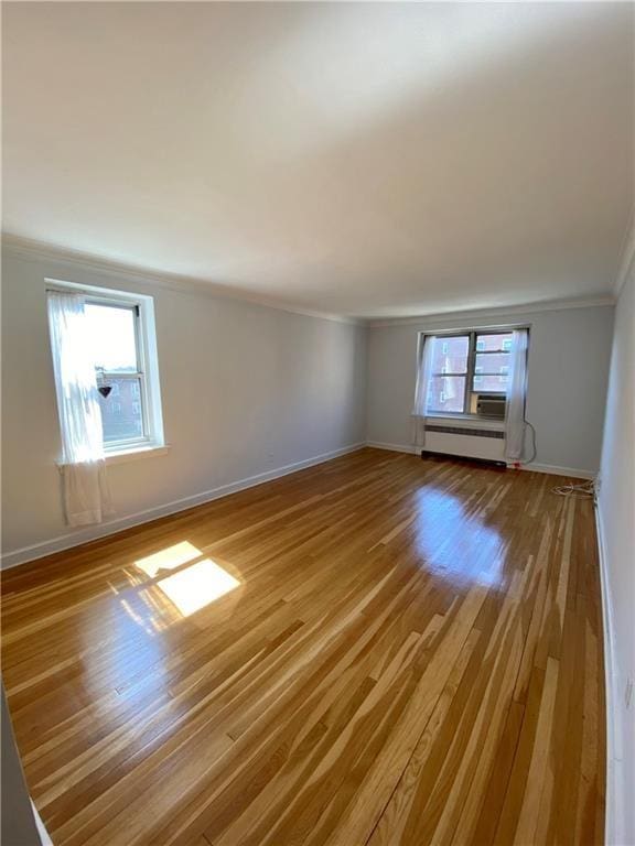 90 Bryant Ave Unit 5B-E, White Plains, NY 10605 - empty room with crown molding, wood finished floors, baseboards, and a baseboard radiator