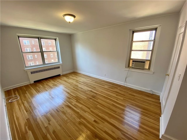 90 Bryant Ave Unit 5B-E, White Plains, NY 10605 - spare room featuring radiator heating unit, wood finished floors, crown molding, baseboards, and cooling unit