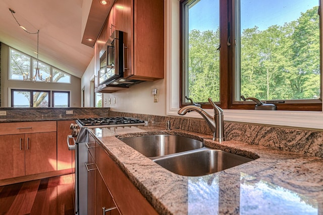 6 Riverside, Cornwall On Hudson, NY 12520 - kitchen with stainless steel appliances, brown cabinets, light stone counters, lofted ceiling, and decorative light fixtures