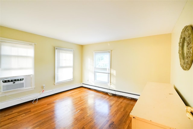 56 Academy St, Patchogue, NY 11772 - empty room featuring wood finished floors, a baseboard heating unit, cooling unit, and baseboard heating