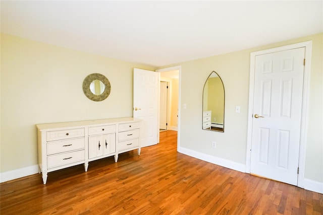 56 Academy St, Patchogue, NY 11772 - unfurnished bedroom with wood finished floors and baseboards