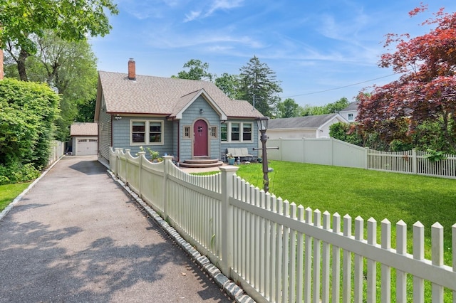 15 Orchard Rd, East Patchogue, NY 11772 - view of front of house featuring an outbuilding, roof with shingles, a chimney, and a garage