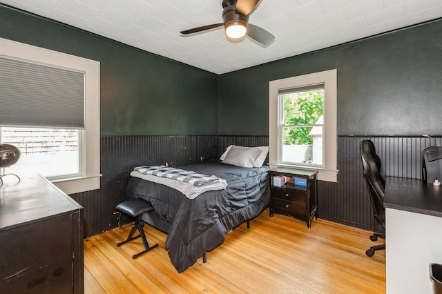 15 Orchard Rd, East Patchogue, NY 11772 - bedroom featuring wood finished floors, a wainscoted wall, a desk, and a ceiling fan