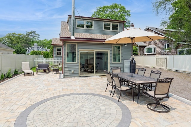 15 Orchard Rd, East Patchogue, NY 11772 - back of property with a patio, a fenced backyard, outdoor dining area, a gate, and roof with shingles