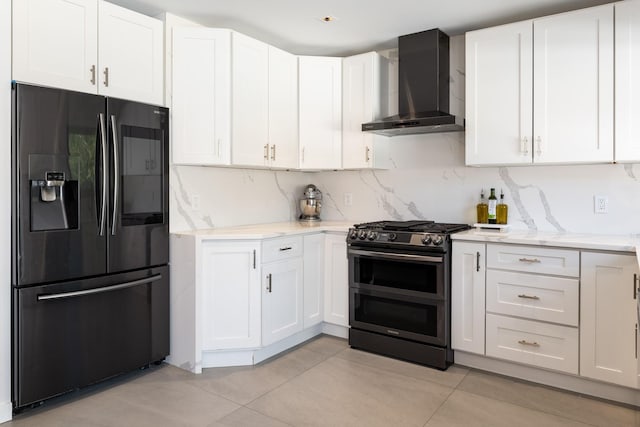 1363 Kearney Ave, Bronx, NY 10465 - kitchen featuring black fridge, wall chimney exhaust hood, double oven range, light tile patterned floors, and white cabinetry