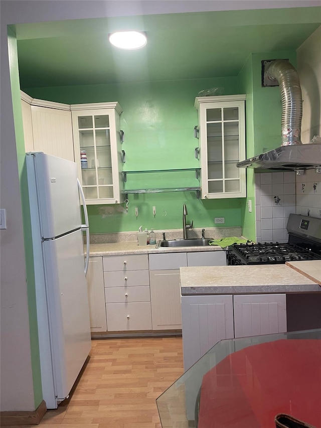 134-54 Maple Ave Unit 2S, Flushing, NY 11355 - kitchen featuring freestanding refrigerator, range hood, gas range, white cabinets, and light countertops
