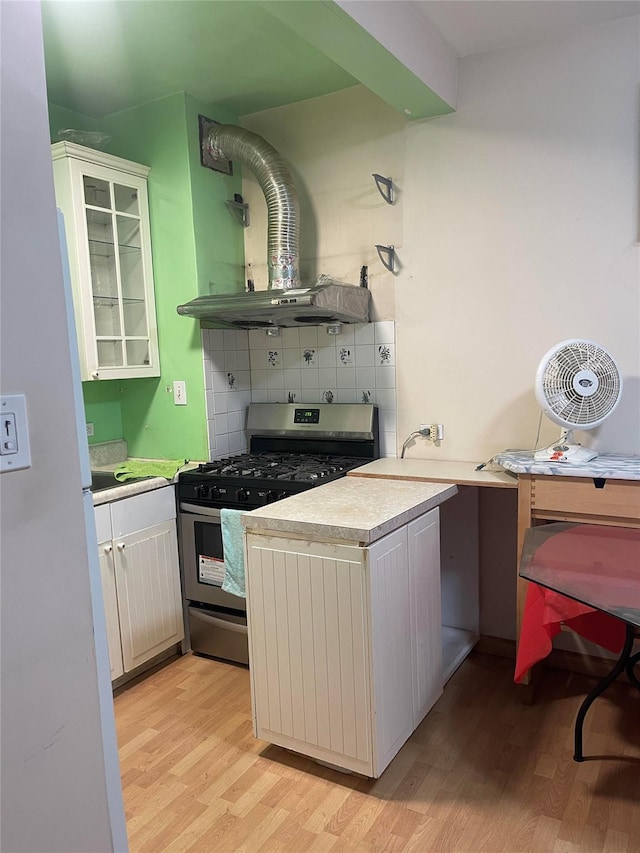 134-54 Maple Ave Unit 2S, Flushing, NY 11355 - kitchen featuring gas stove, light wood-style flooring, light countertops, exhaust hood, and glass insert cabinets