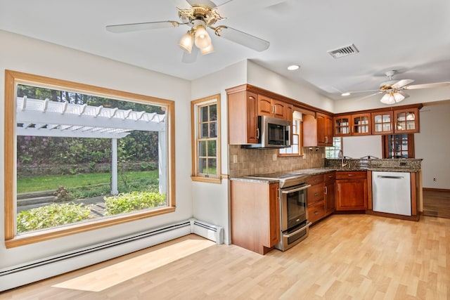 206 Lower Sheep Pasture Rd, Setauket, NY 11733 - kitchen featuring appliances with stainless steel finishes, a baseboard heating unit, ceiling fan, light wood-type flooring, and tasteful backsplash