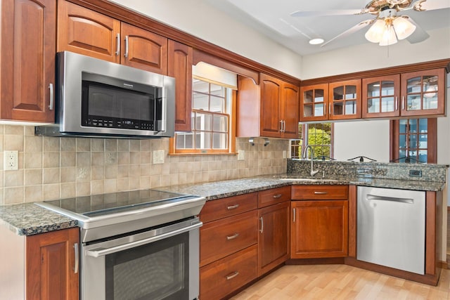 206 Lower Sheep Pasture Rd, Setauket, NY 11733 - kitchen featuring appliances with stainless steel finishes, a ceiling fan, light wood finished floors, glass insert cabinets, and brown cabinetry