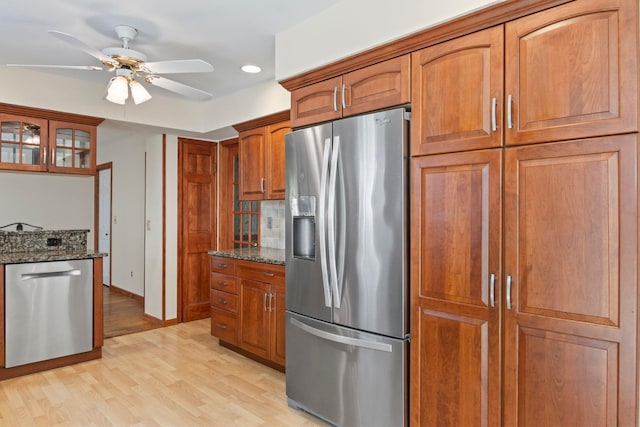 206 Lower Sheep Pasture Rd, Setauket, NY 11733 - kitchen featuring stainless steel appliances, dark stone counters, ceiling fan, light wood finished floors, and brown cabinets