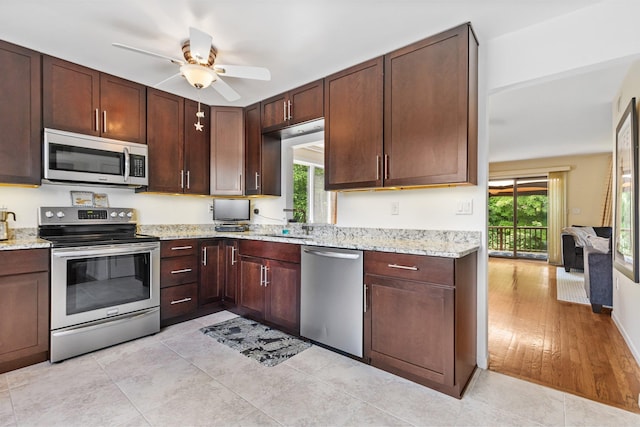 59 Krystal Dr, Somers, NY 10589 - kitchen with appliances with stainless steel finishes, a ceiling fan, light stone countertops, and dark brown cabinetry