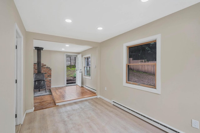 18 Port Jefferson Rd, Sound Beach, NY 11789 - foyer entrance with baseboard heating, light wood-type flooring, a wood stove, recessed lighting, and baseboards