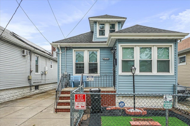 10712 Sutter Ave, Ozone Park, NY 11417 - view of front of home with a fenced front yard and a shingled roof