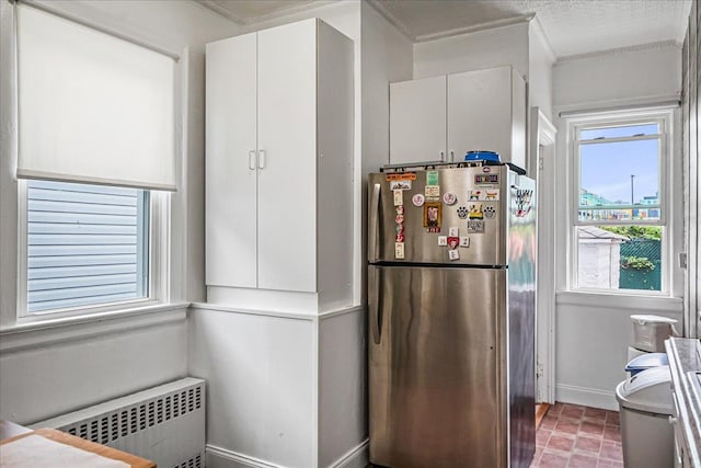 10712 Sutter Ave, Ozone Park, NY 11417 - kitchen with freestanding refrigerator, radiator heating unit, healthy amount of natural light, ornamental molding, and white cabinetry