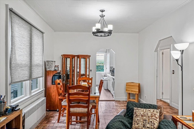 10712 Sutter Ave, Ozone Park, NY 11417 - dining area featuring radiator, arched walkways, a chandelier, and ornamental molding