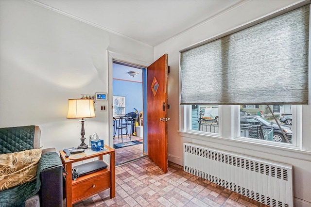 10712 Sutter Ave, Ozone Park, NY 11417 - living area featuring radiator heating unit, brick patterned floors, and crown molding