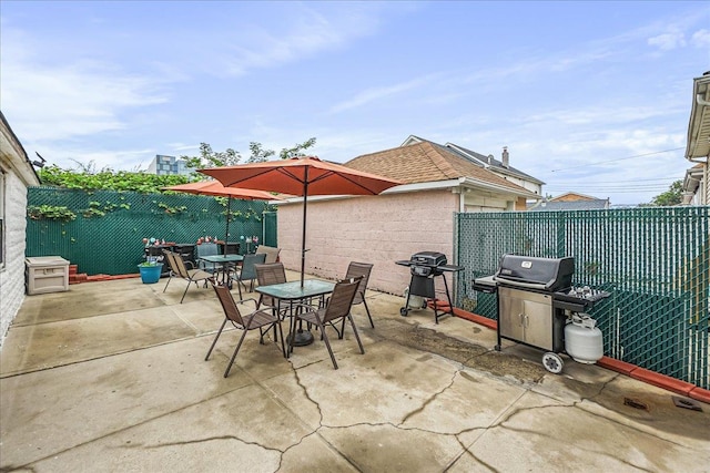 10712 Sutter Ave, Ozone Park, NY 11417 - fenced backyard featuring outdoor dining area, a grill, and a patio