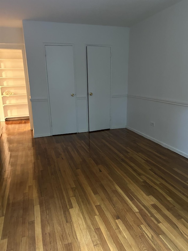 43-25 Douglaston Pkwy Unit 2D, Douglaston, NY 11363 - unfurnished bedroom featuring dark wood-style floors and baseboards