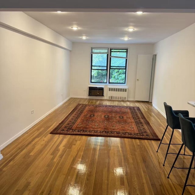 43-25 Douglaston Pkwy Unit 2D, Douglaston, NY 11363 - empty room with radiator heating unit, wood finished floors, and an AC wall unit