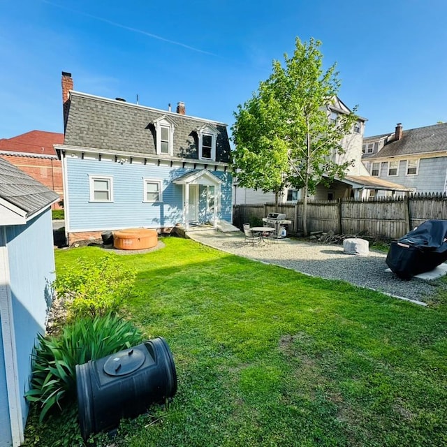 22 Spring St, Port Chester, NY 10573 - back of house featuring a hot tub, a shingled roof, a chimney, mansard roof, and a patio area