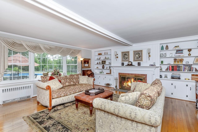 2 The Spout, Smithtown, NY 11787 - living room featuring radiator, wood finished floors, a brick fireplace, crown molding, and built in shelves