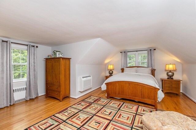 2 The Spout, Smithtown, NY 11787 - bedroom with radiator heating unit, light wood-style floors, and lofted ceiling