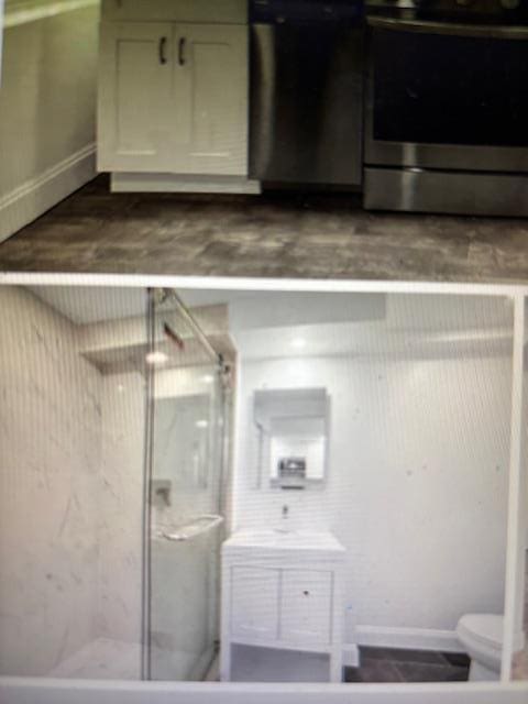 135 Saint Marks Ave, Brooklyn, NY 11217 - bathroom with a shower stall, baseboards, toilet, and vanity