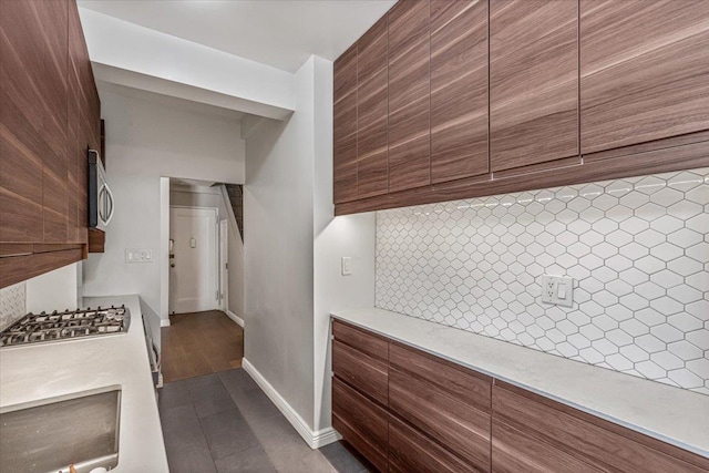 99-40 63rd Rd Unit 1Z, Rego Park, NY 11374 - kitchen featuring stainless steel appliances, modern cabinets, backsplash, light countertops, and brown cabinetry