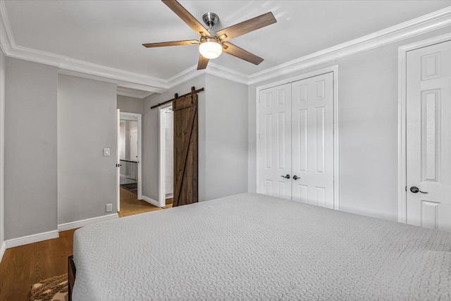 99-40 63rd Rd Unit 1Z, Rego Park, NY 11374 - unfurnished bedroom with a barn door, ornamental molding, a closet, wood finished floors, and a ceiling fan