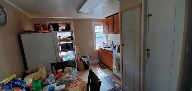77 Carroll St, Poughkeepsie, NY 12601 - kitchen featuring white appliances, brown cabinetry, light tile patterned floors, and light countertops