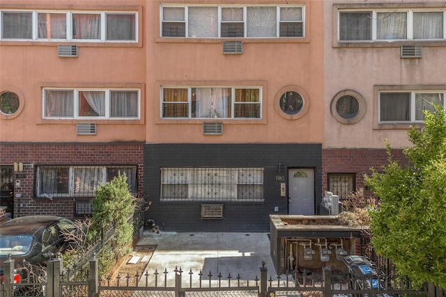 1180 Sherman Ave, Bronx, NY 10456 - view of building exterior with a fenced front yard and a wall unit AC