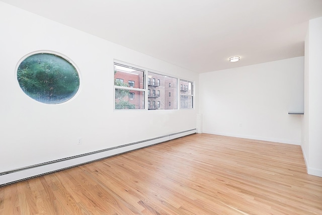 1180 Sherman Ave, Bronx, NY 10456 - unfurnished room featuring a baseboard heating unit, light wood-type flooring, and baseboards