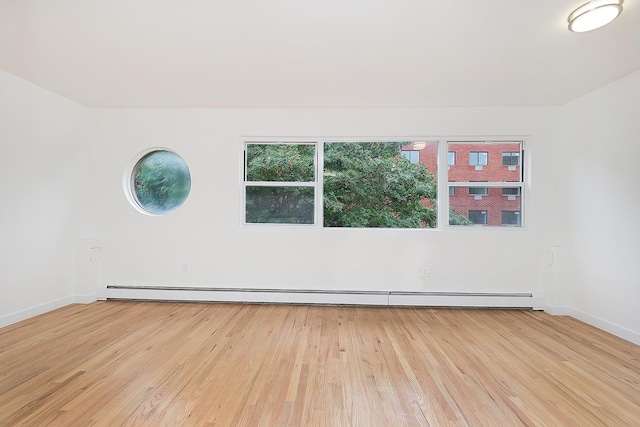 1180 Sherman Ave, Bronx, NY 10456 - empty room with baseboard heating, light wood-style flooring, and baseboards