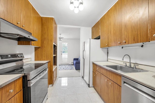 25 Chapel Pl Unit 3N, Great Neck, NY 11021 - kitchen featuring stainless steel appliances, under cabinet range hood, a sink, and brown cabinets
