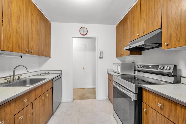 25 Chapel Pl Unit 3N, Great Neck, NY 11021 - kitchen with appliances with stainless steel finishes, under cabinet range hood, a sink, brown cabinets, and light countertops