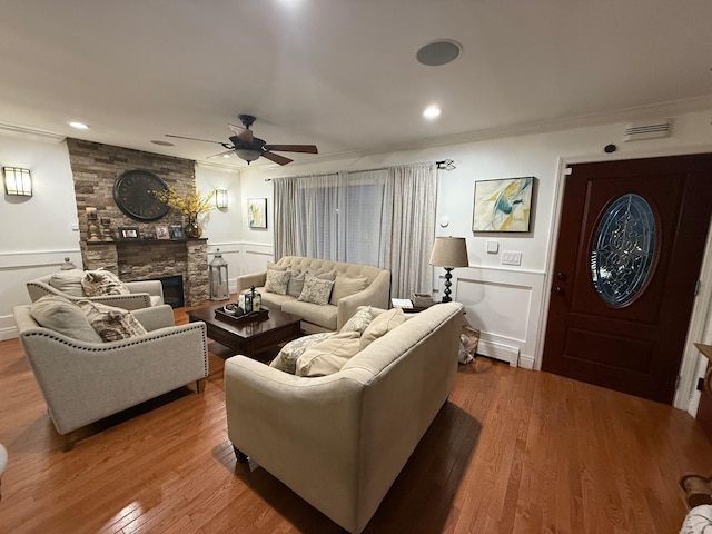 1803 Front St, East Meadow, NY 11554 - living area with ornamental molding, a ceiling fan, a decorative wall, a fireplace, and wood finished floors