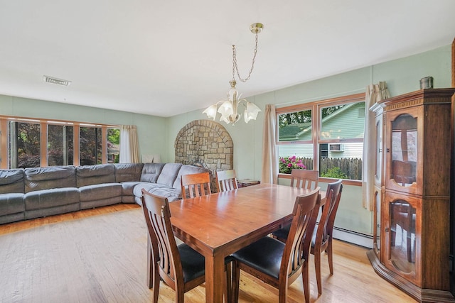21 Spectacle Lake Dr, Smithtown, NY 11767 - dining area with a chandelier, baseboard heating, light wood-type flooring, and healthy amount of natural light