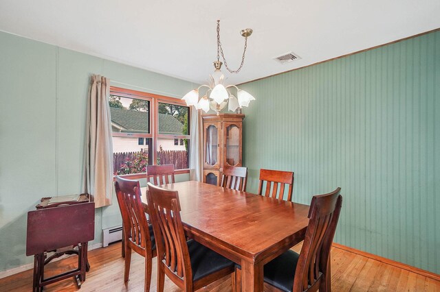 21 Spectacle Lake Dr, Smithtown, NY 11767 - dining room featuring a baseboard heating unit, a chandelier, light wood-type flooring, and crown molding