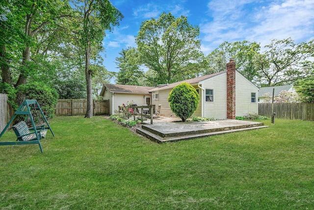 21 Spectacle Lake Dr, Smithtown, NY 11767 - rear view of house with a deck, a fenced backyard, and a chimney