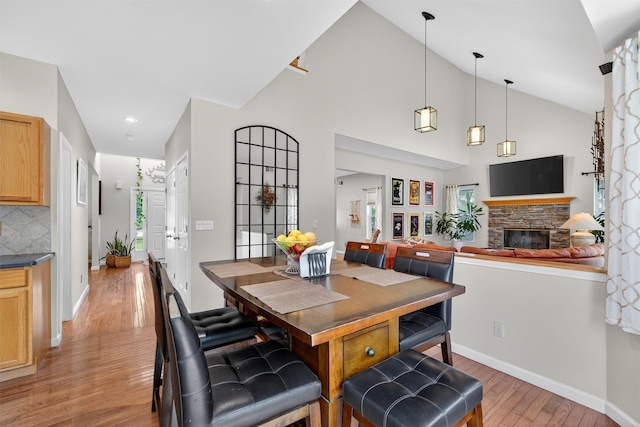 11 Pacer Ct, Goshen, NY 10924 - dining room with light wood-style flooring, a stone fireplace, vaulted ceiling, and recessed lighting