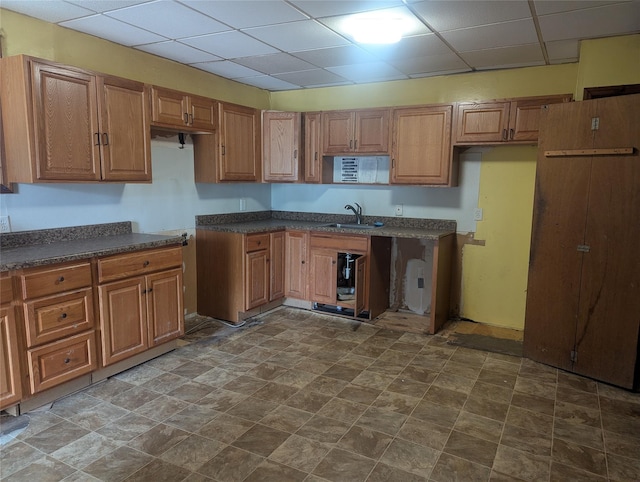 265 Goodwill Rd, Montgomery, NY 12549 - kitchen featuring a paneled ceiling, dark countertops, brown cabinetry, and stone finish flooring