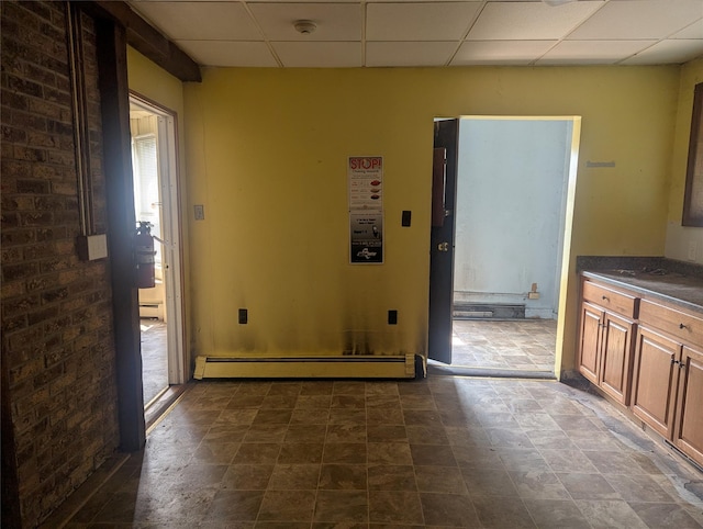 265 Goodwill Rd, Montgomery, NY 12549 - interior space with a baseboard heating unit, a paneled ceiling, baseboard heating, and dark stone finish floors